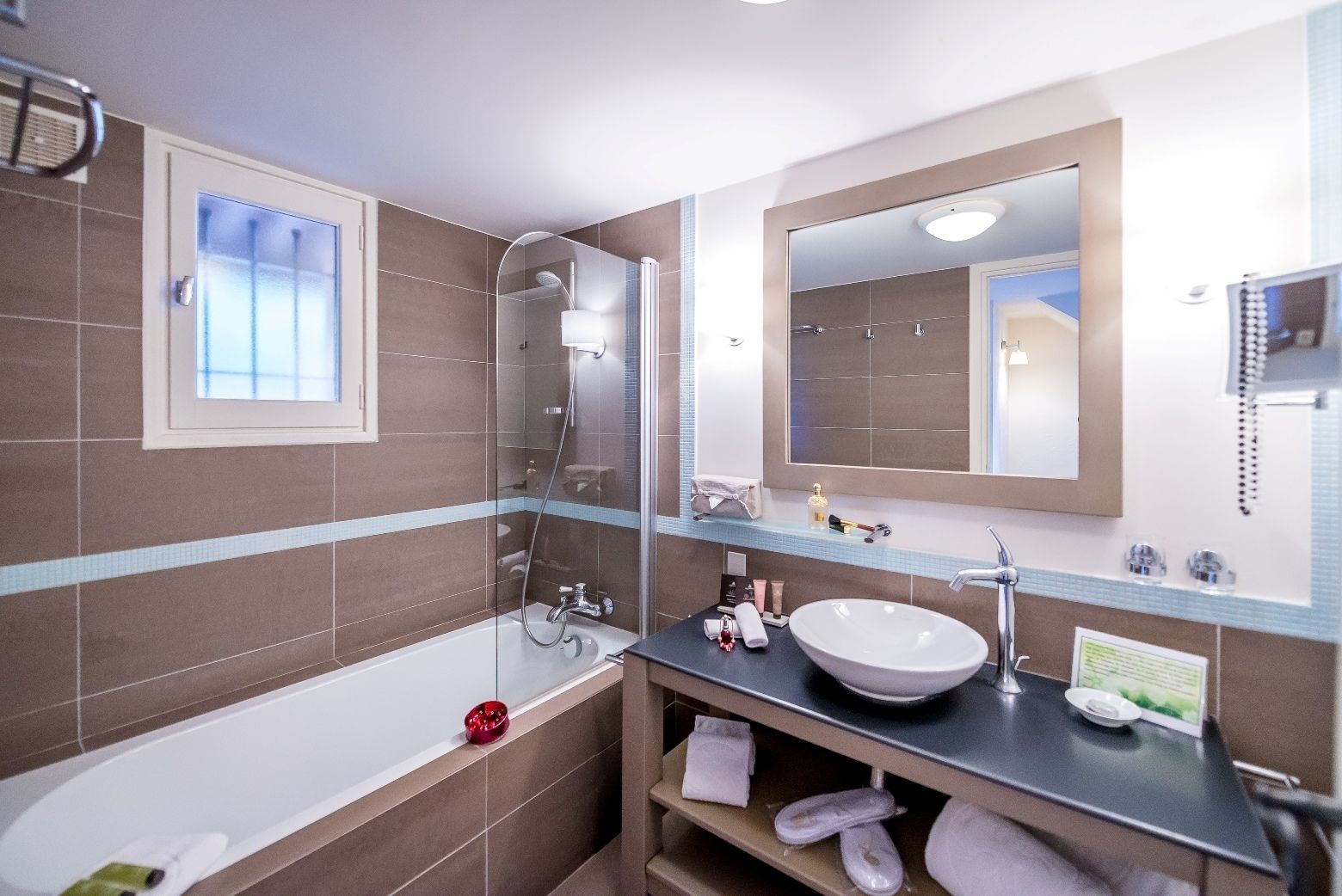 A modern bathroom with a bathtub, a shower, a sink, and a large mirror.