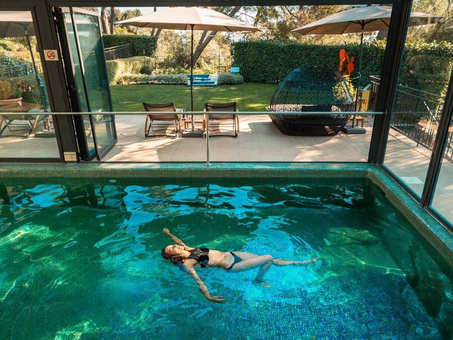 Una piscina techada, una piscina al aire libre de temporada, sombrillas