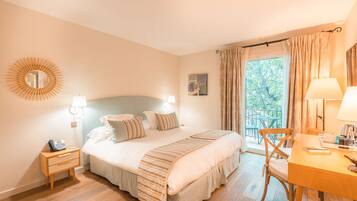 Un dormitorio con cama, mesitas de noche, una silla y una ventana con cortinas.
