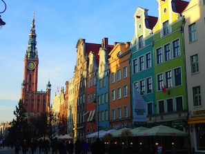 A historic street with colorful buildings, a prominent clock tower, and outdoor seating areas. - Apartament Nadmorski Sopot 1 (Sopot)