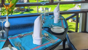A table set for dining with a view of palm trees and the ocean. - Cocoa Luxury Resort, Nyali (Mombasa)
