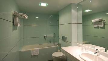 Un baño moderno con ducha envuelta en vidrio, una bañera, un inodoro y un lavabo con espejo.