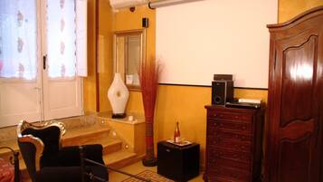 A room with a staircase, a white vase, a red vase, a wooden cabinet, and a speaker.