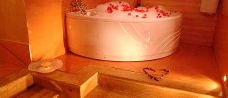 A modern bathroom with a freestanding bathtub, wooden steps, and a towel rack.