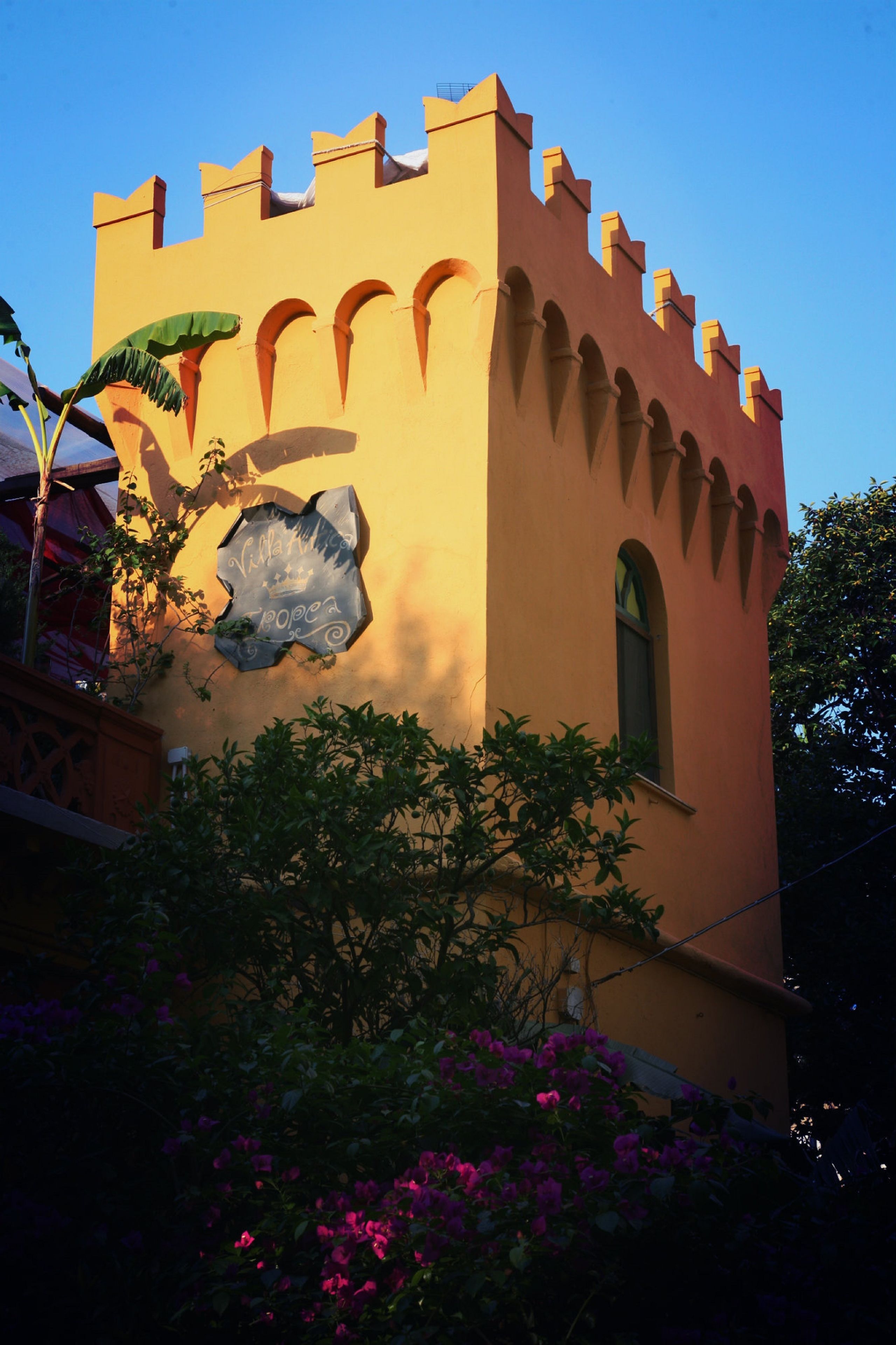 A tower with arched windows and a decorative stone piece.