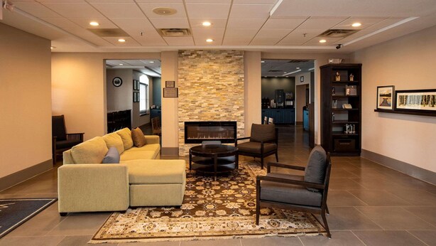 A spacious lobby with a sectional sofa, a fireplace, and a coffee table. - Country Inn & Suites by Radisson, Wilson, NC (Wilson)