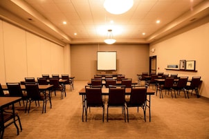 Un salón de conferencias con mesas y sillas dispuestas para reuniones.