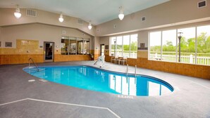 An indoor swimming pool with clear lanes, a lifeguard chair, and a view of the outdoors through large windows. - Country Inn & Suites by Radisson, Wilson, NC (Wilson)