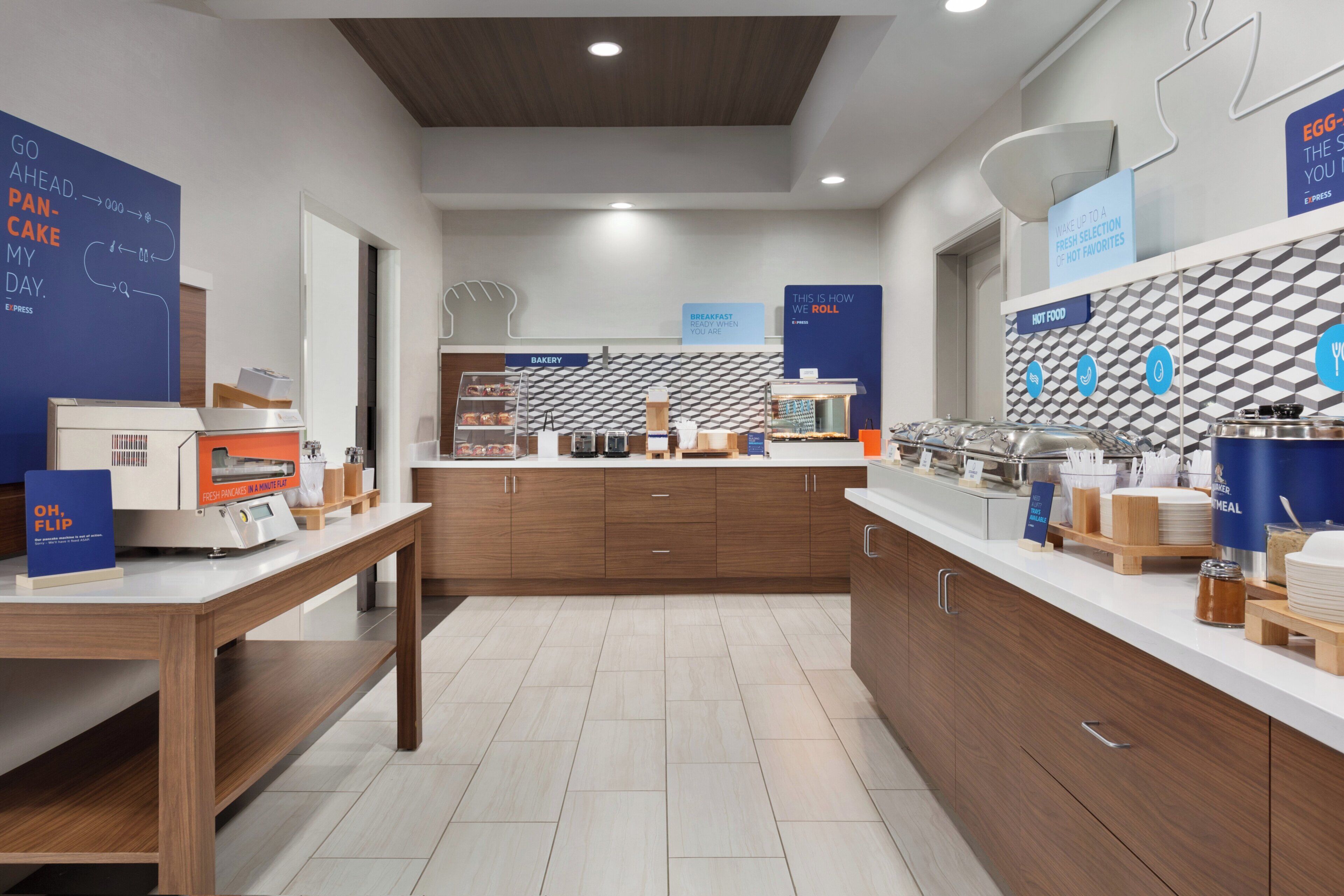 A modern kitchen area with a bakery section, a breakfast bar, and various food service equipment.
