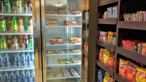 A vending area with two freezers and shelves stocked with snacks and beverages. - Holiday Inn Express Hotel & Suites Merced by IHG (Merced)