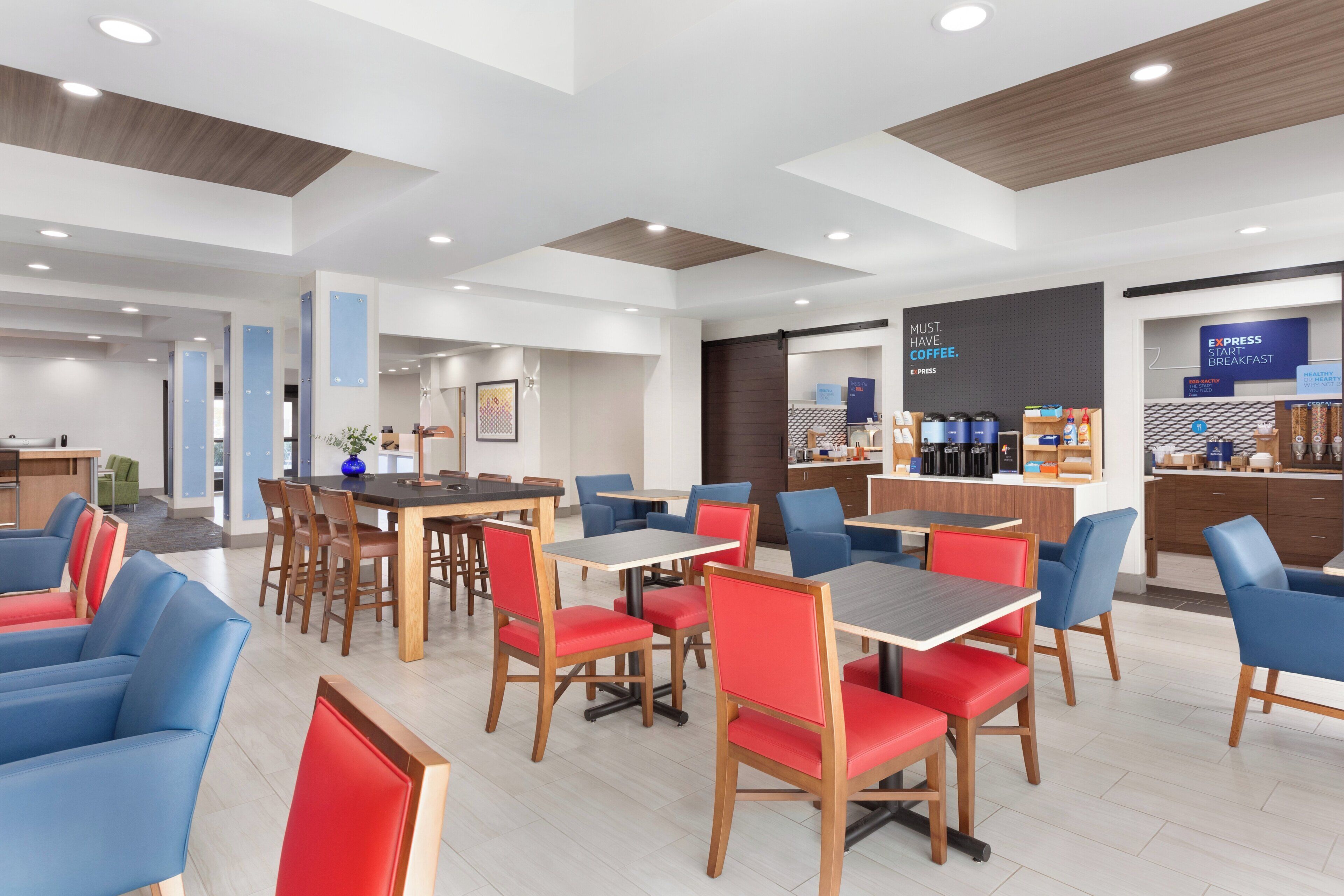 A modern cafe with multiple seating areas, including tables and chairs, and a coffee bar with various coffee-making equipment.