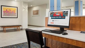 Ein Empfangsschalter mit einem Computer, einer Bank und gerahmten Kunstwerken an der Wand.