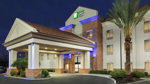 A Holiday Inn Express hotel with a covered entrance, stone facade, and palm trees. - Holiday Inn Express Hotel & Suites Merced by IHG (Merced)