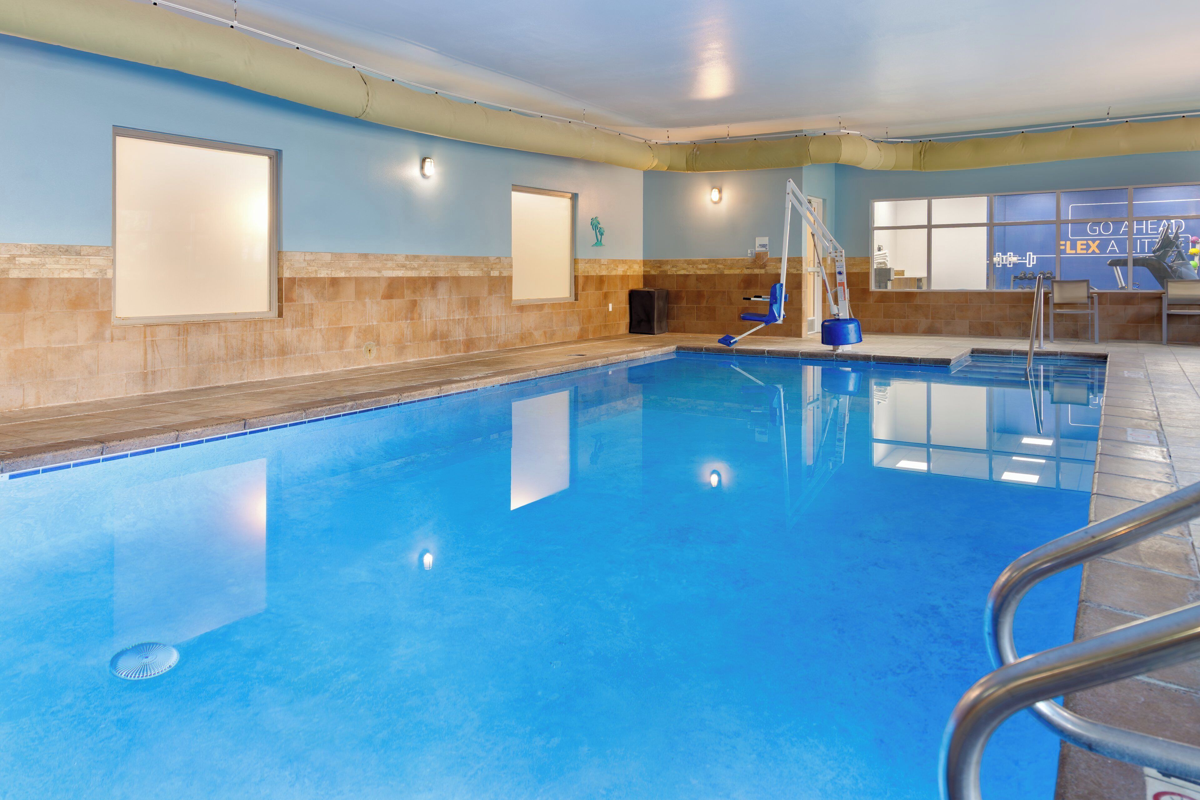 Una piscina techada, sillones reclinables de piscina