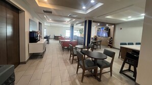 A spacious indoor area with multiple seating arrangements, including tables and chairs, and a counter area with a coffee machine. - Holiday Inn Express Hotel & Suites Twin Falls by IHG (Twin Falls)