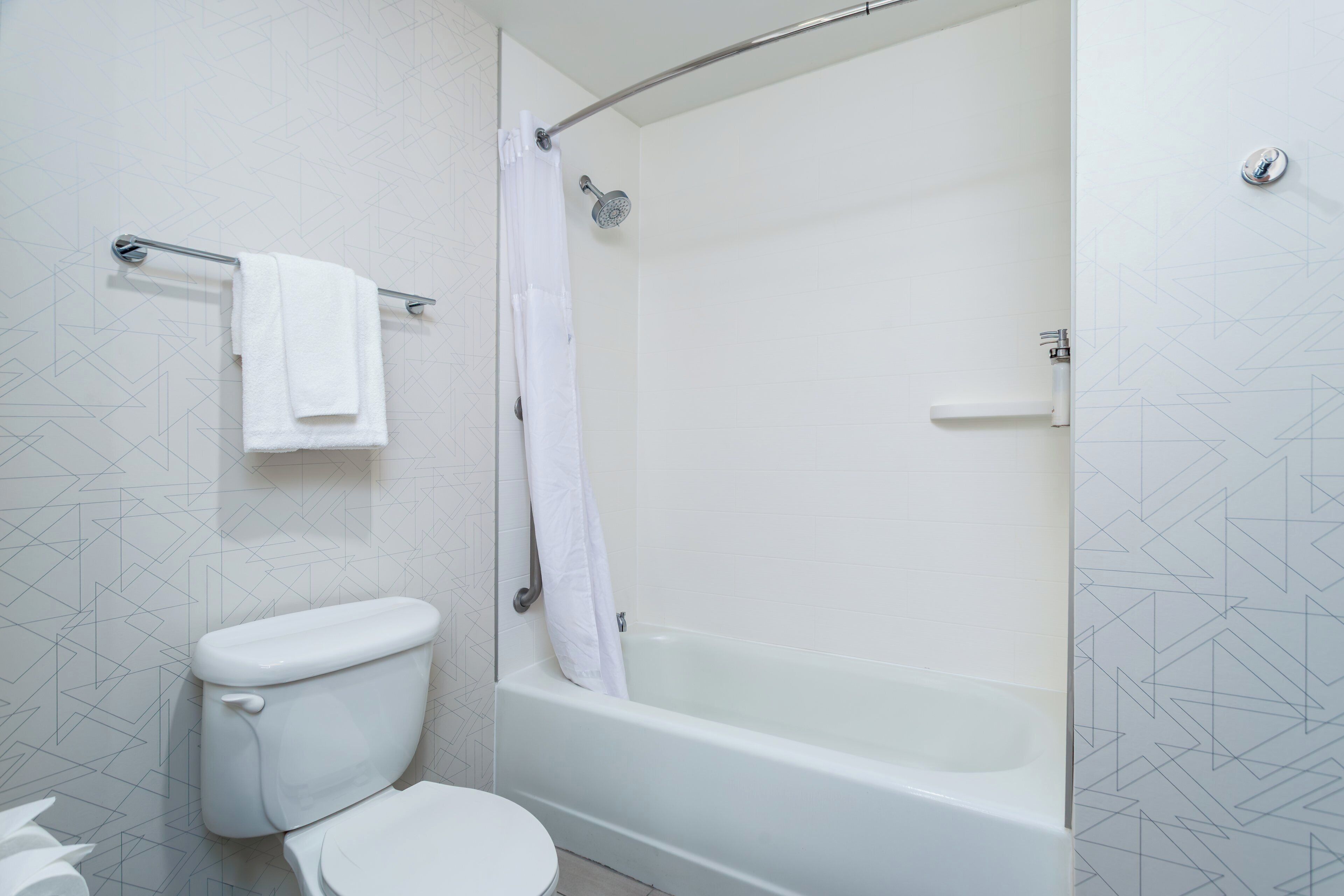 Un baño con inodoro, bañera y cortina de ducha.