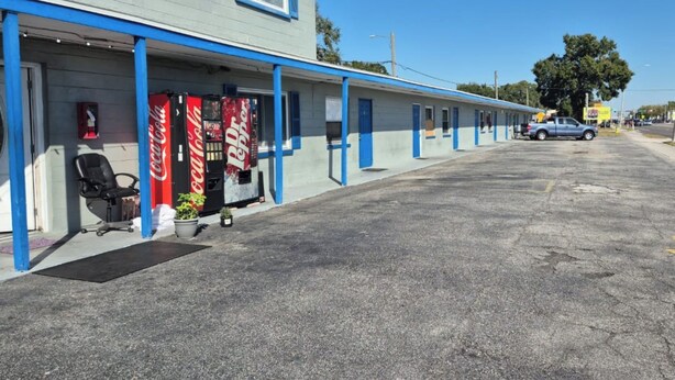 Ein Motel mit einer Reihe von Zimmern, einem Coca-Cola-Schild und einem Dr. Pepper-Schild.