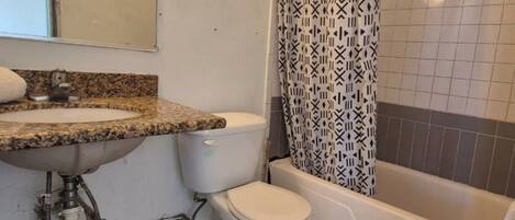 A bathroom with a sink, toilet, and bathtub.