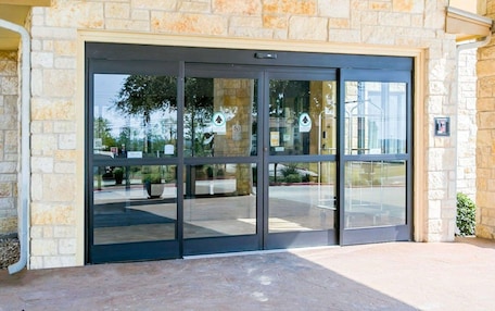 A stone building with a large glass door entrance.