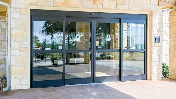 A stone building with a large glass door entrance. - Sleep Inn & Suites Gonzales near Palmetto State Park (Gonzales)