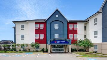 Situated in a well-maintained area, Candlewood Suites features a modern architectural design with a prominent entrance and clearly marked parking spaces.