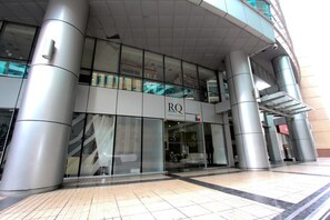 Un edificio moderno con fachada de vidrio y un letrero que dice "RQ".