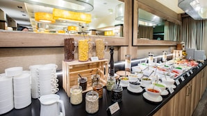 Un bufé con diversos alimentos y recipientes.