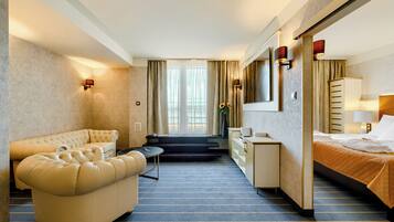 Une chambre d’hôtel avec un canapé, un lit, un bureau et un miroir.