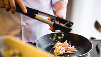 A person cooking in a pan with a spatula.