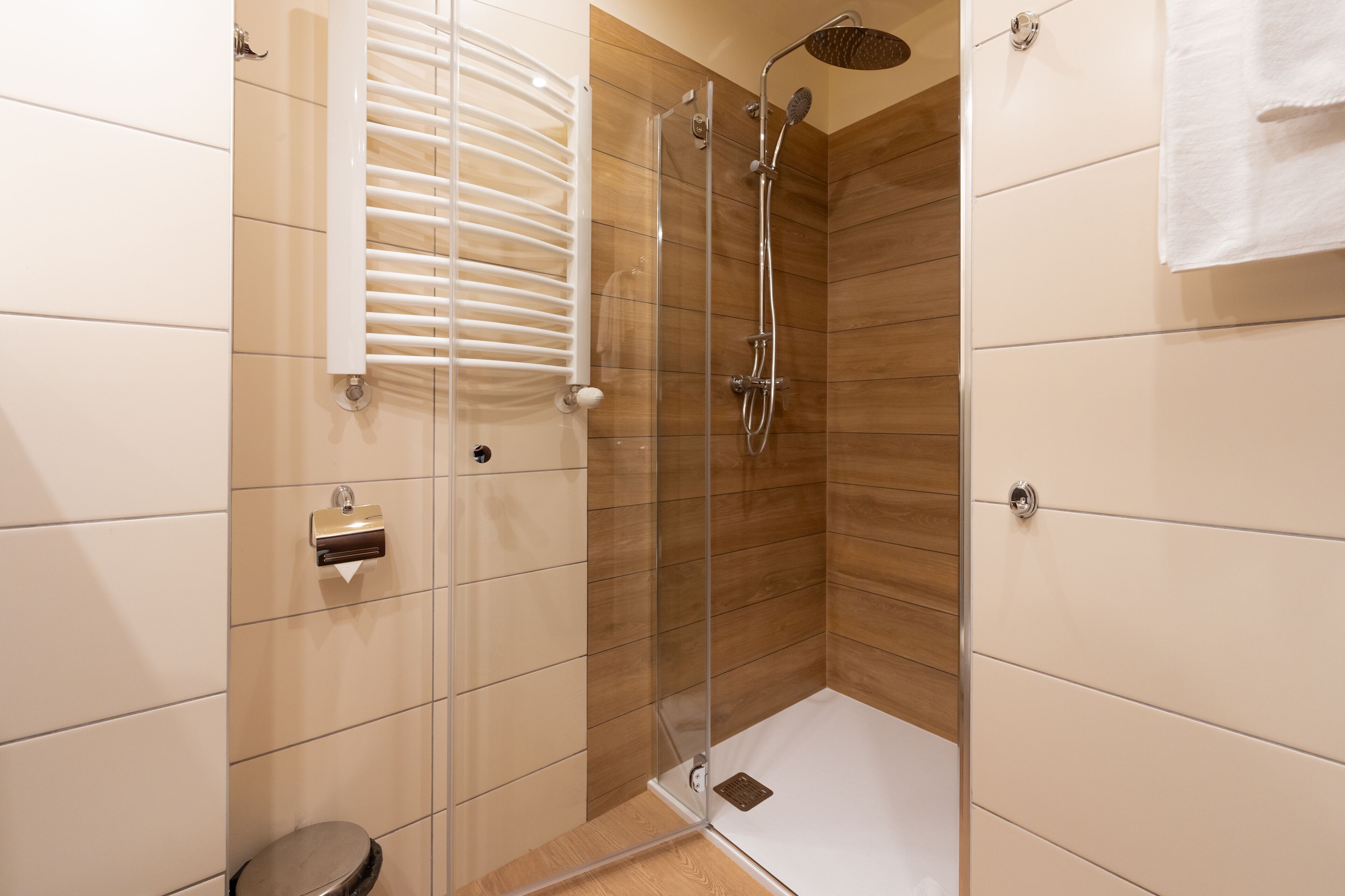 Un baño moderno con ducha de vidrio, inodoro y perchero para toallas.