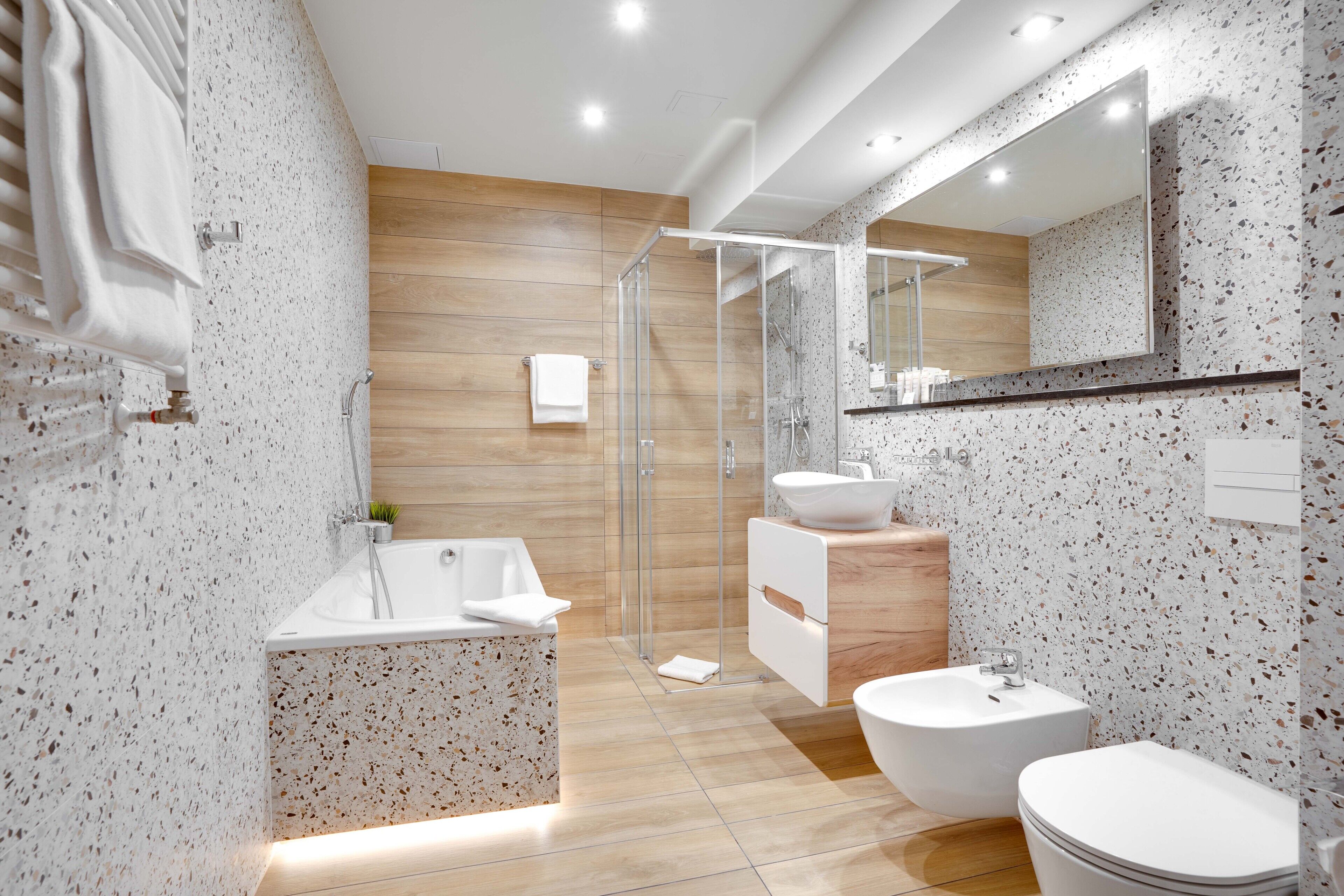 Une salle de bain moderne avec une baignoire sur pieds, une douche à parois de verre, un lavabo et des toilettes.
