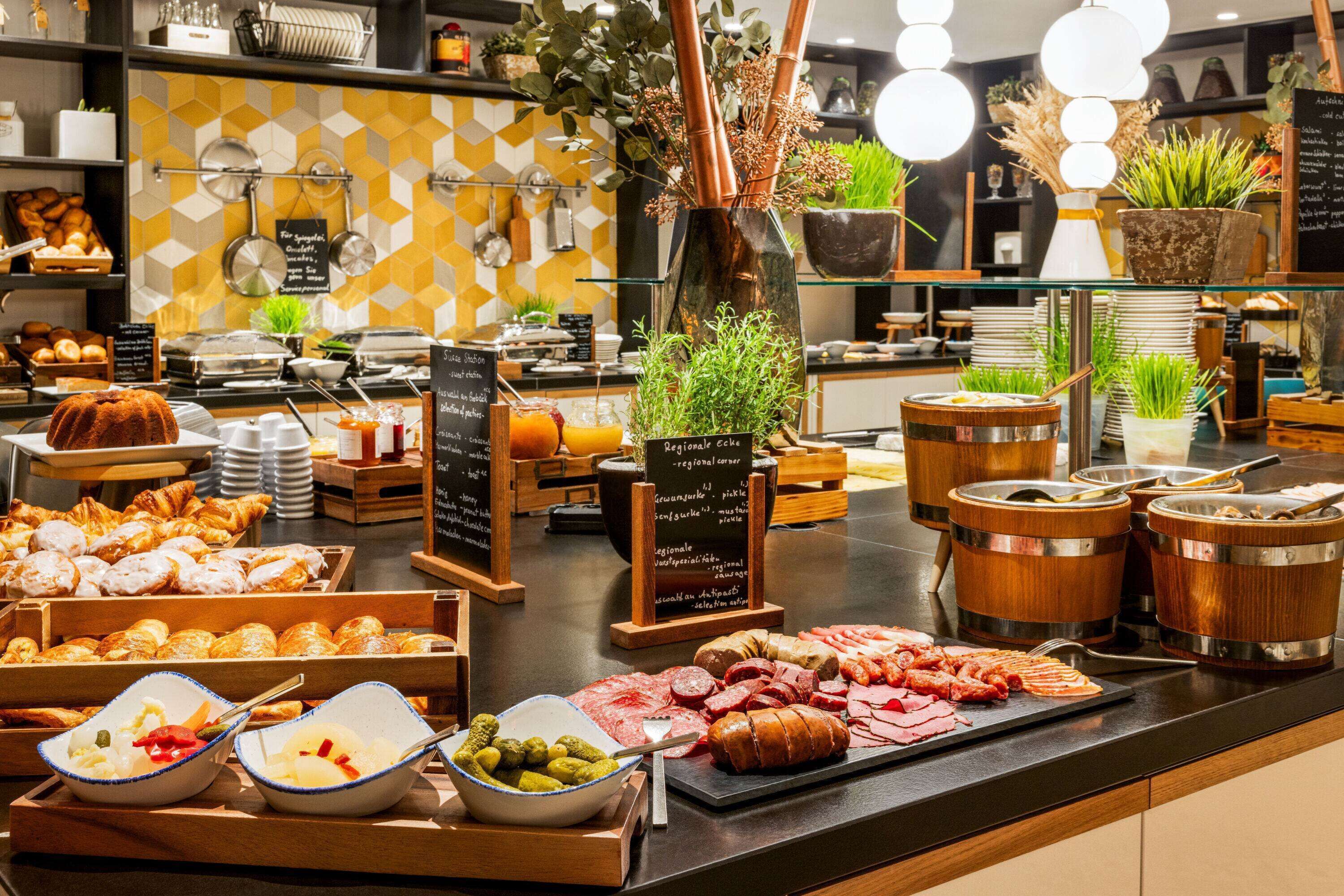 Ein Buffet mit verschiedenen Speisen, darunter Backwaren, Fleisch und eine Salatschüssel.