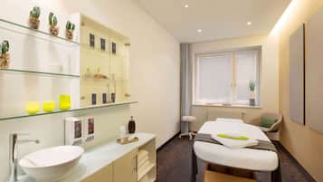 Relax in a clean and minimalist space with a comfortable seating area, oval-shaped sink, and glass-fronted medicine cabinet.