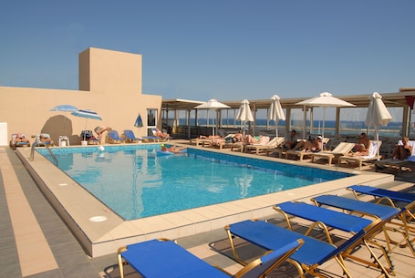 Una piscina al aire libre de temporada, sombrillas