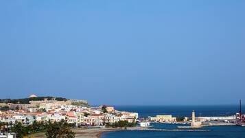 A coastal town with historic buildings, a fort, and a lighthouse.