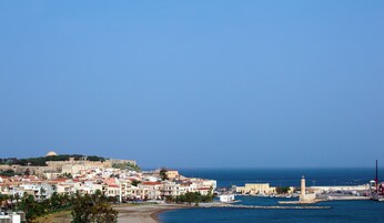A coastal town with historic buildings, a fort, and a lighthouse.