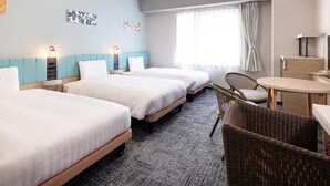 Une chambre d’hôtel avec trois lits, un bureau, une chaise et une grande fenêtre avec des rideaux.