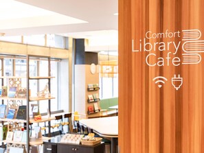 Un accogliente caffè letterario moderno con scaffali in legno, libri e un bancone per caffè.
