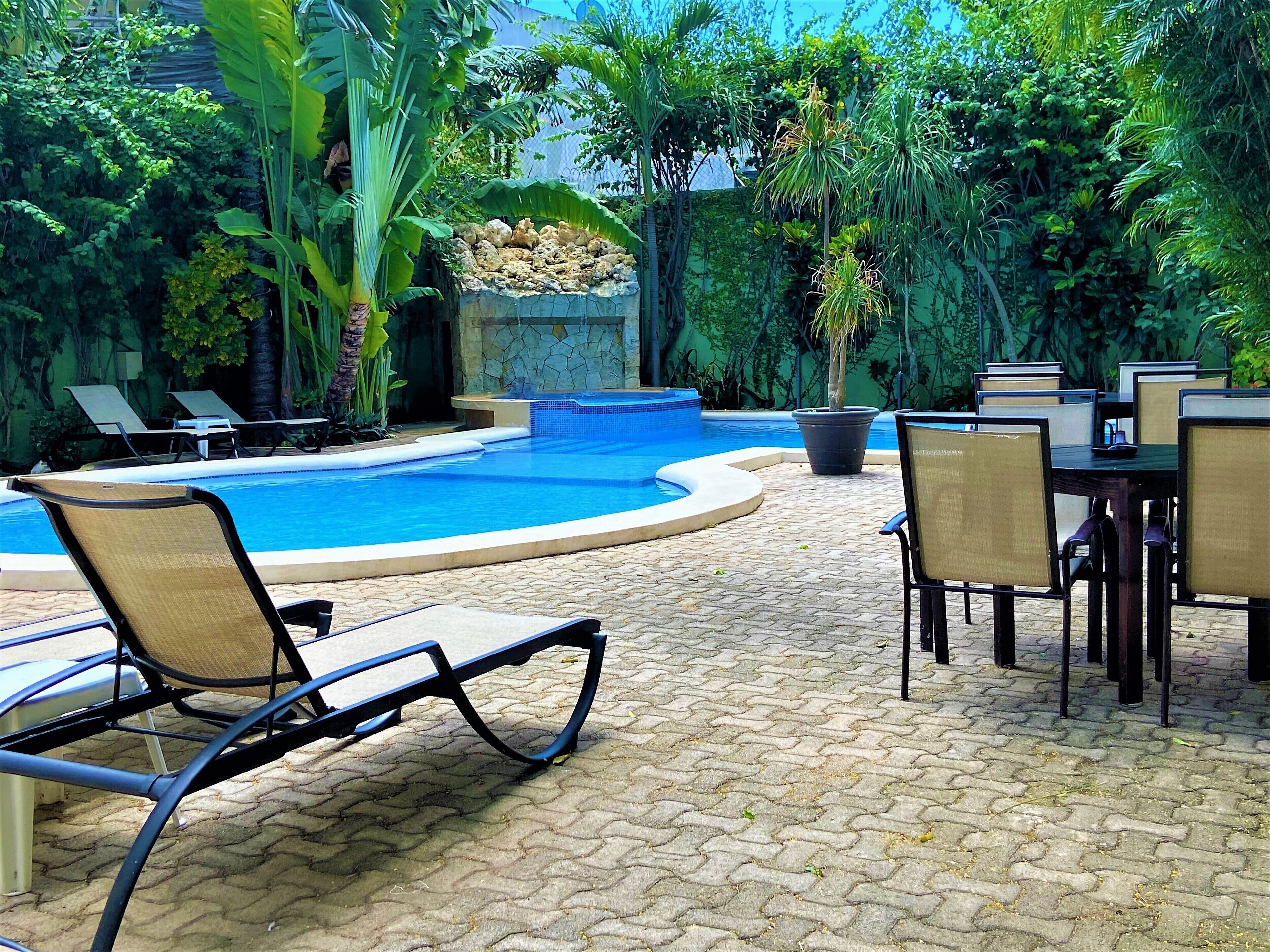 A poolside area with lounge chairs and a dining table.