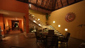 A spacious indoor area with a staircase, seating area, and a decorative wall.