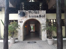 Indgangen til Hotel Luna Sol, med en stenbuet indgang og et skilt over.