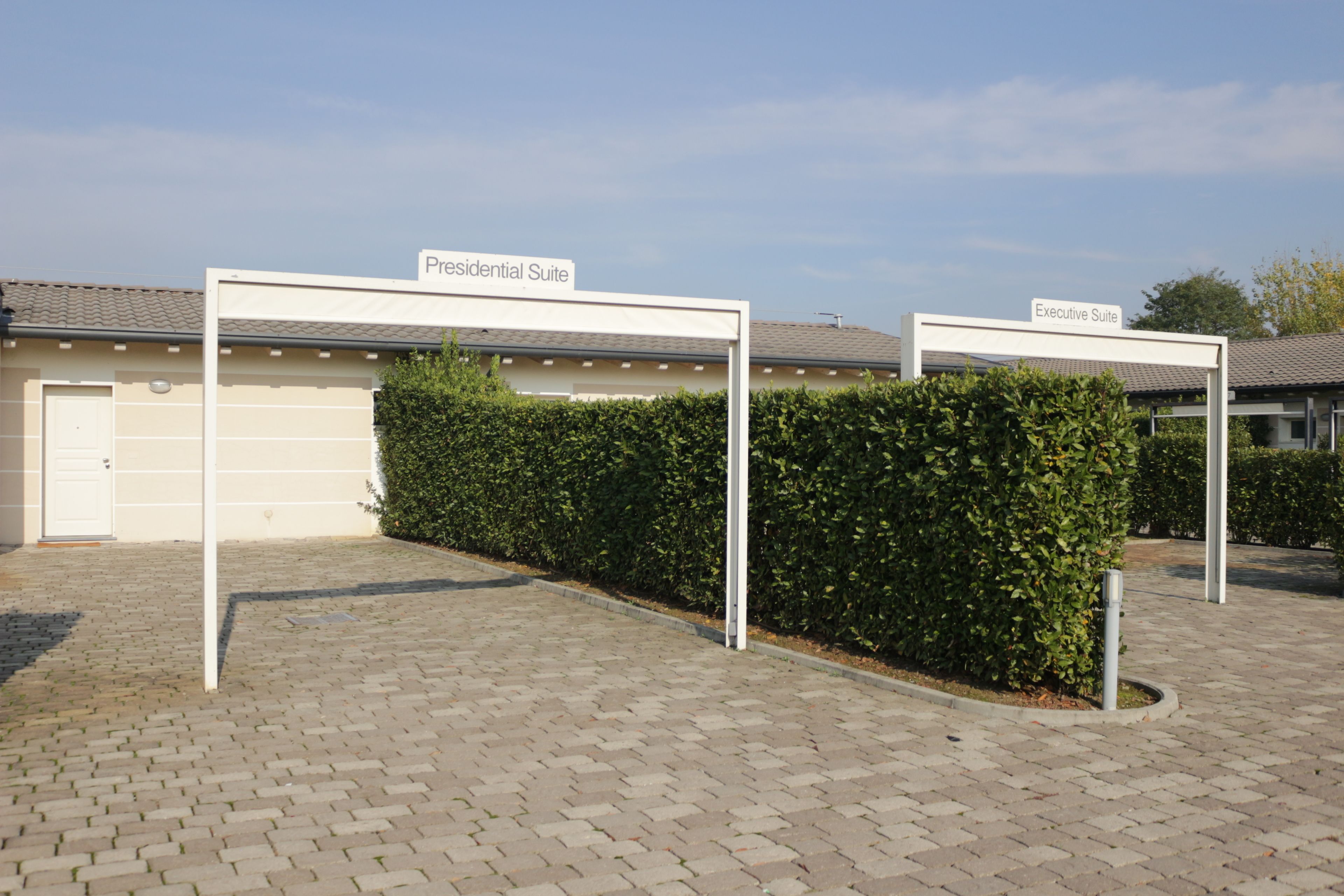 A residential building with a paved driveway and two labeled gates for a "Presidential Suite" and an "Executive Suite."