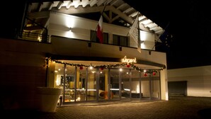Een hotel met een moderne gevel, grote glasramen en een bord met daarop 'Hotel'.
