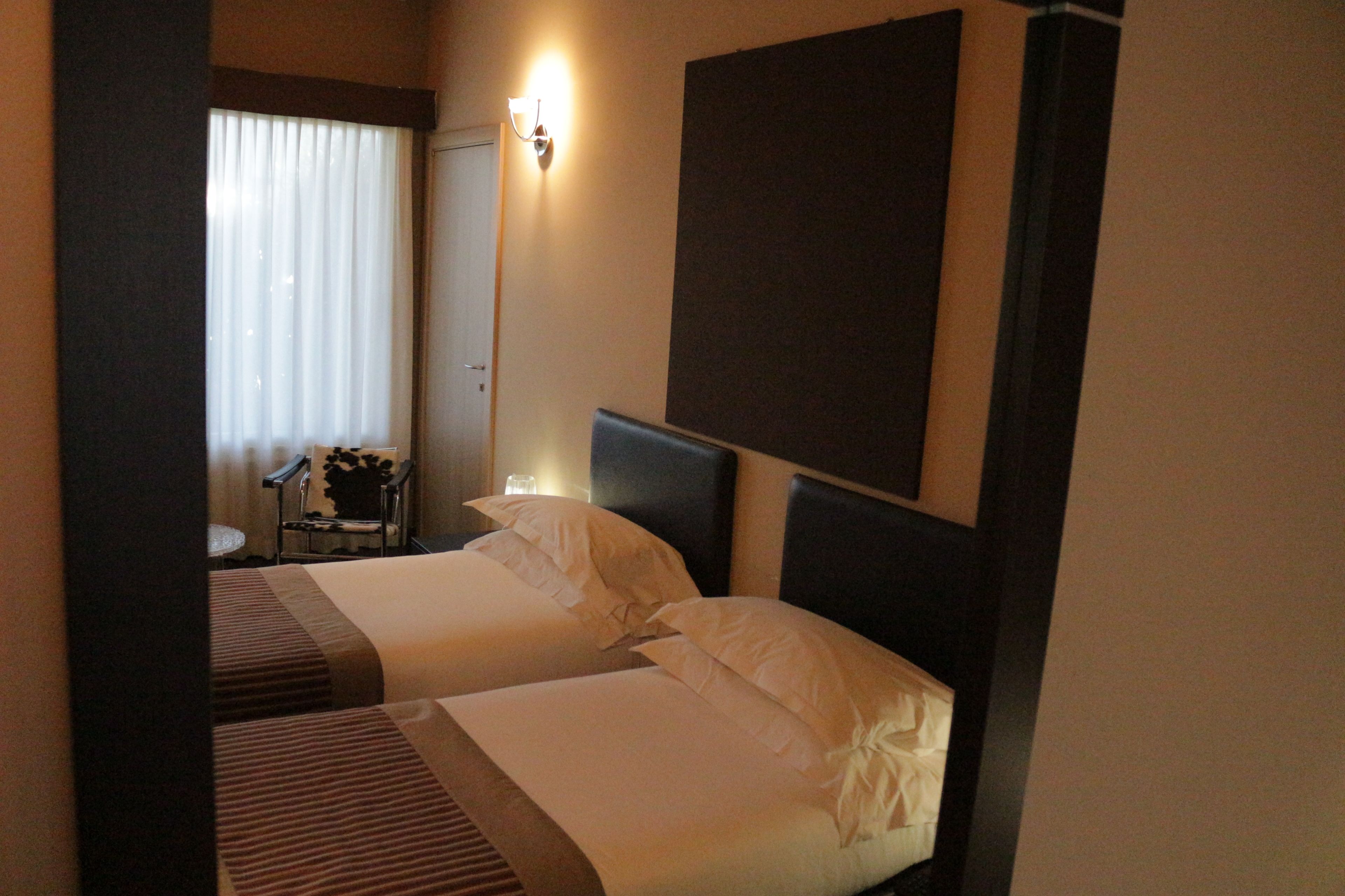 Habitación de hotel con dos camas, un escritorio y una silla.