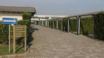 A pathway leading to a building with directional signs indicating various suites and exits.
