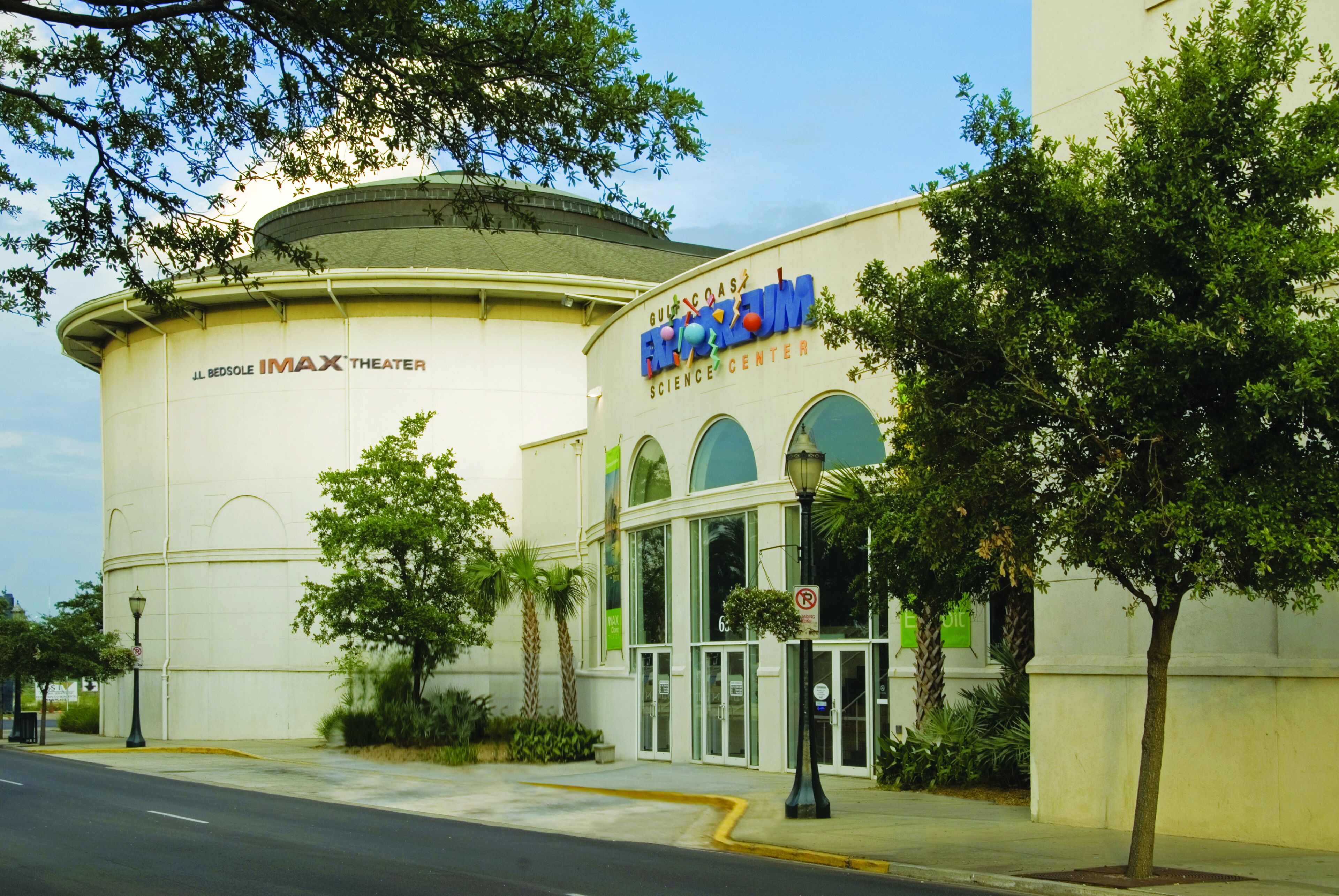 Un bâtiment doté d’une grande structure en forme de dôme, sur la façade duquel on peut lire les inscriptions « IMAX Theater » et « Gulf Coast Science Center ».