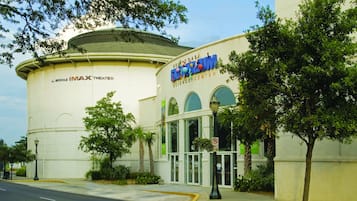 Un bâtiment doté d’une grande structure en forme de dôme, sur la façade duquel on peut lire les inscriptions « IMAX Theater » et « Gulf Coast Science Center ».