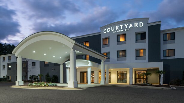 A Courtyard by Marriott hotel with a covered entrance, multiple floors, and a well-lit facade. - Courtyard by Marriott Mobile Daphne/Eastern Shore (Spanish Fort)