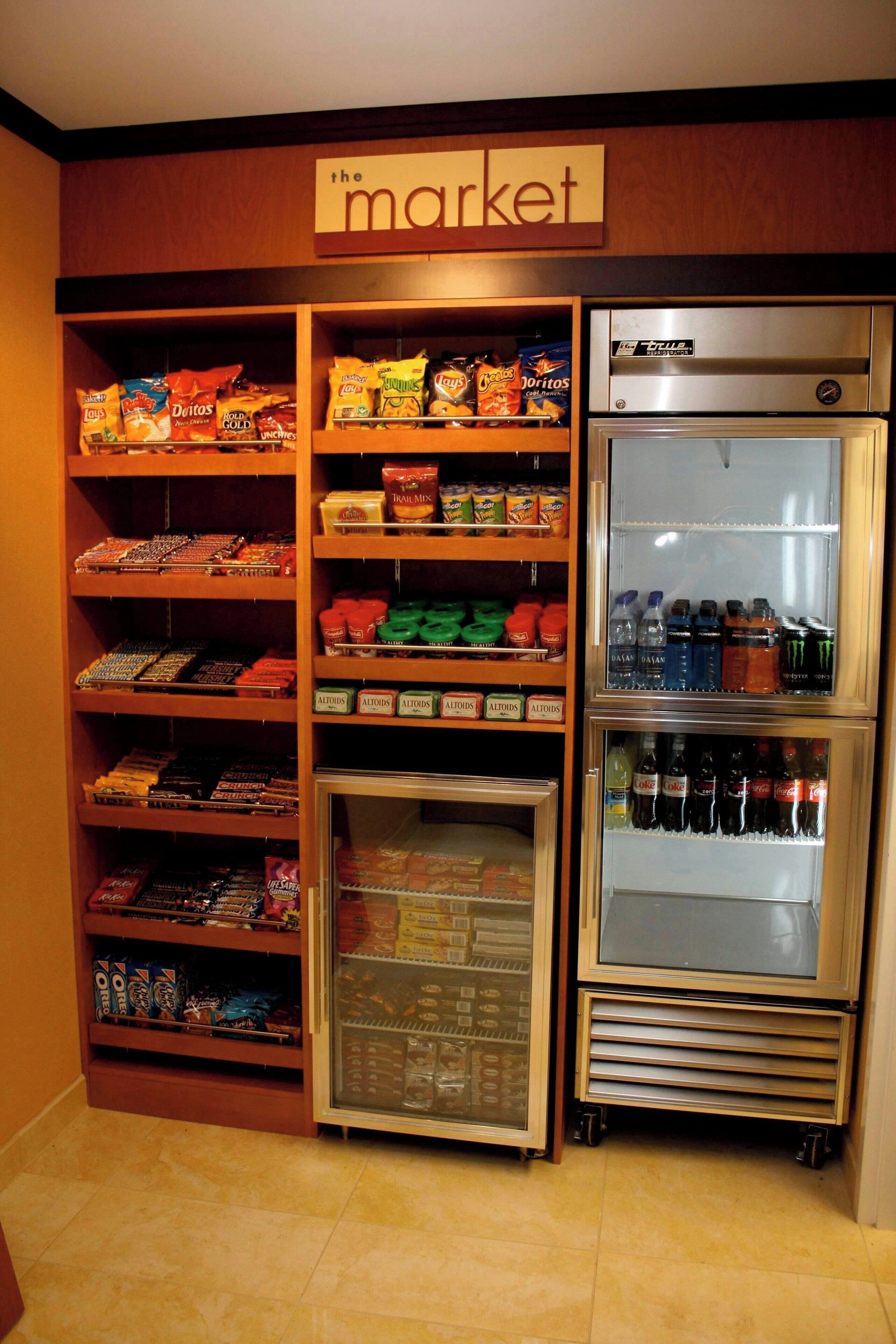 A snack and beverage display in a store with a 'The Market' sign above.