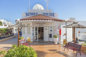 A building labeled "Sunset View Club" with a reception area, outdoor seating, and a well-maintained garden. - Sunset View Club (San Miguel de Abona)